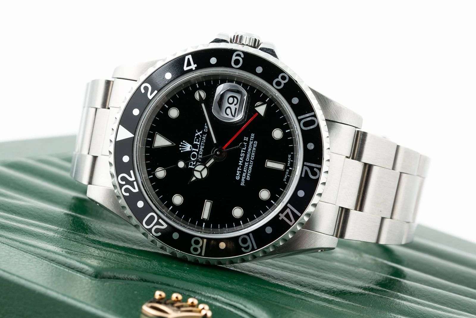 Rolex GMT-Master II ref. 16710 à lunette noire, posée sur sa boîte verte d'origine