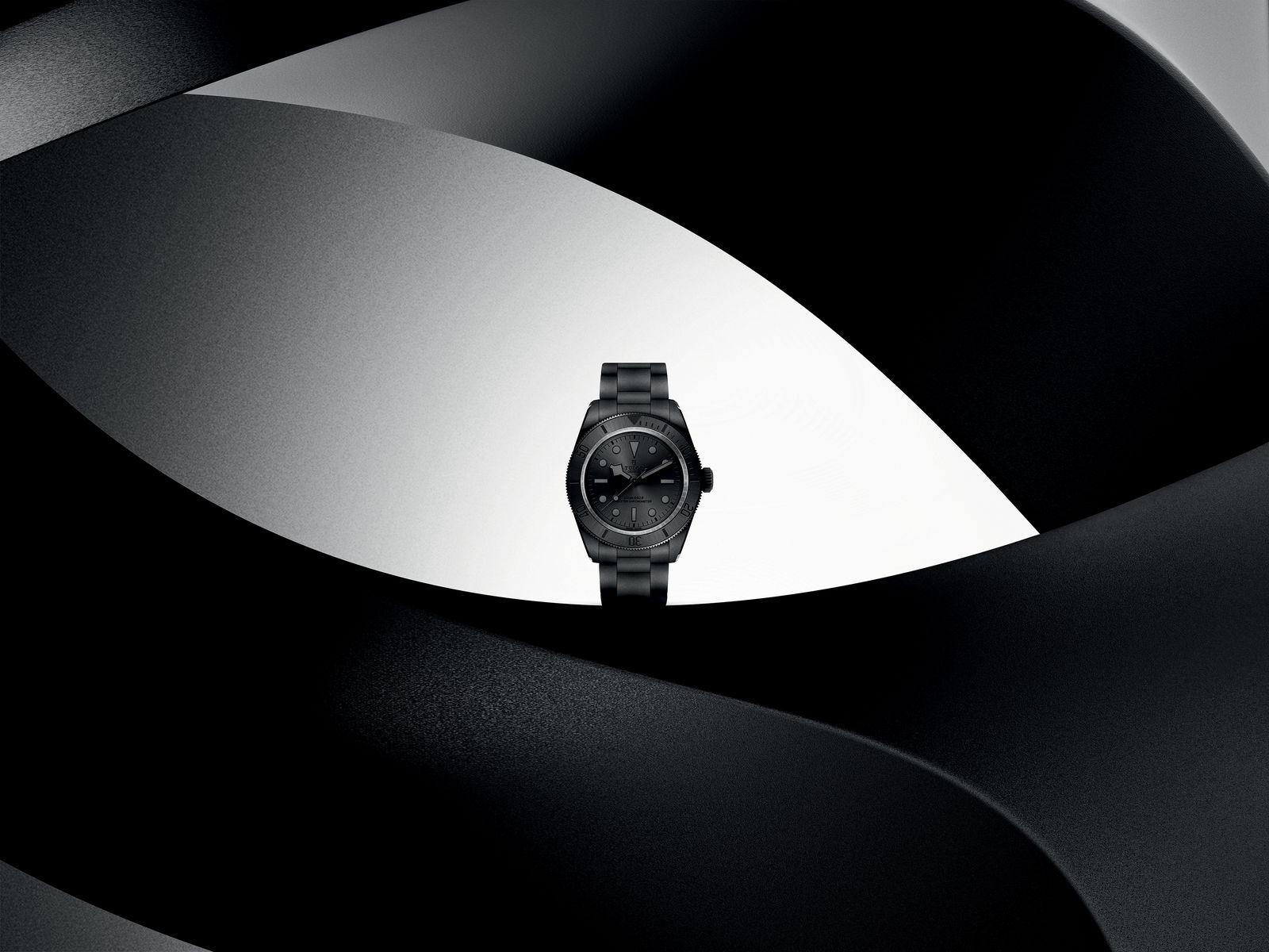 Tudor Black Bay Ceramic 7941A1ACNU sur bracelet céramique, posée sur une courbe noire et blanche